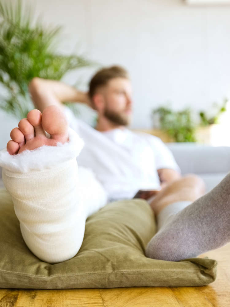 Man on couch with leg in a cast